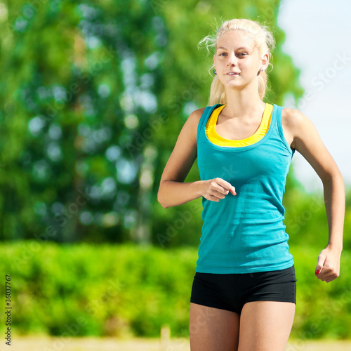 Young woman running in green park