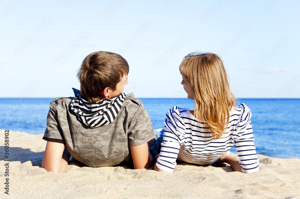 happy pair of male and female on coast behind blue sea happy pair of male and female on coast behind blue sea