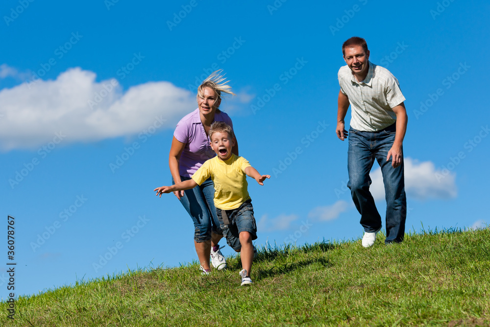 Familie im Freien läuft auf einer Wiese Familie im Freien läuft auf einer Wiese