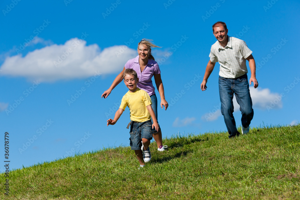 Family outdoors is running on a meadow Family outdoors is running on a meadow