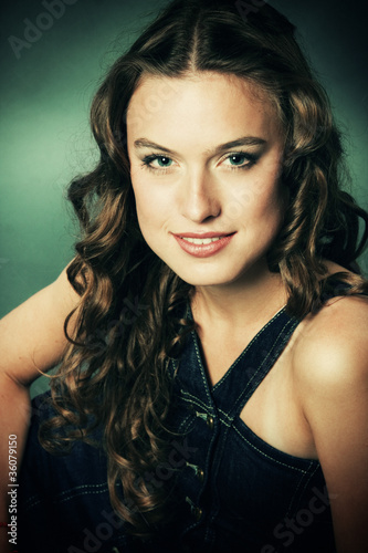 Portrait of a smiling pretty young girl with long ringlets hair