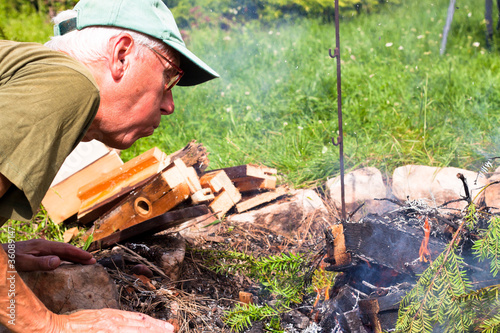 Senior man making bonfire