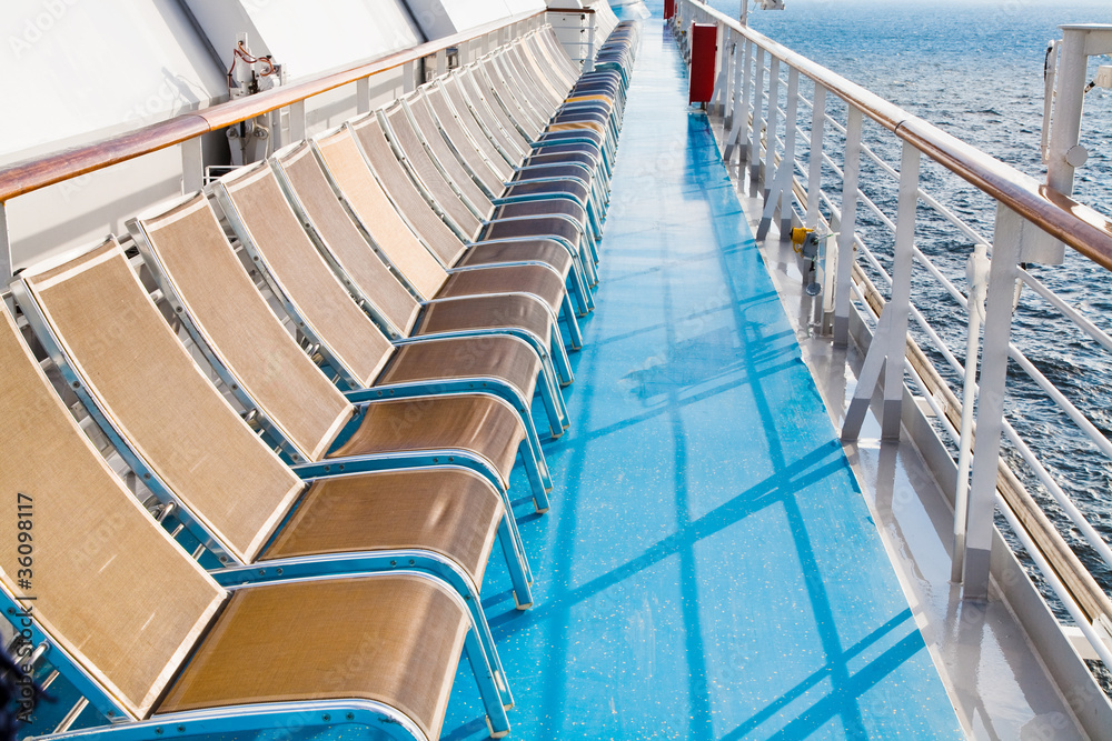 Fototapeta premium sunbath chairs on side of cruise liner