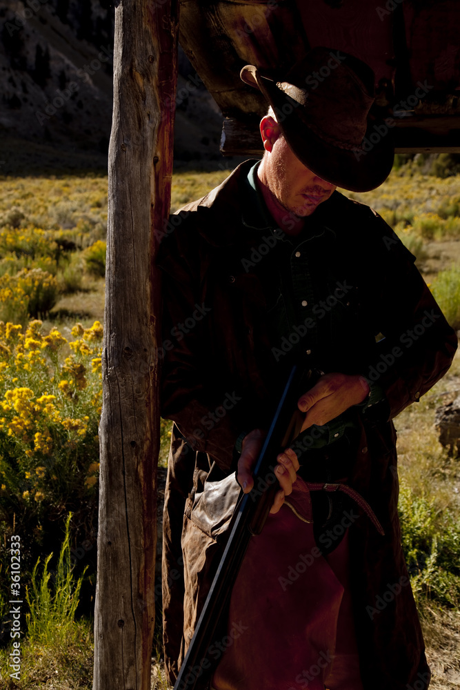 Fototapeta premium cowboy by post with gun