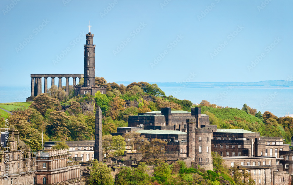 View of Calton Hill at Edinburgh, Scotland, with National Monument and Nelson Monument and sea in a distance