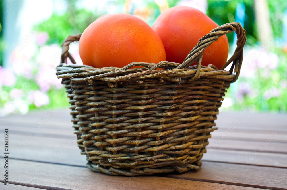 straw basket full of  tomatoes