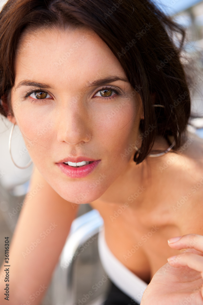 Naklejka premium Portrait of pretty young businesswoman sitting outdoor at cafe a