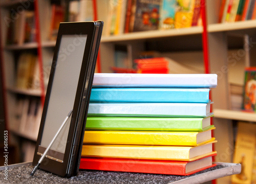 Obraz na płótnie Stack of colorful books with electronic book reader w salonie