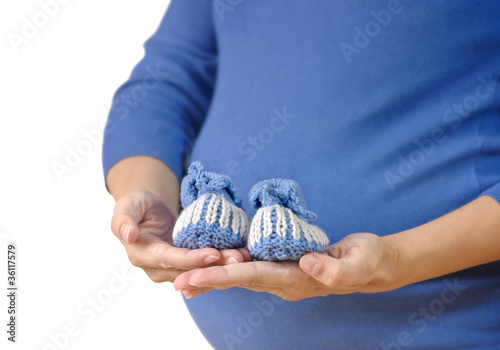 Pregnant woman holding baby booties