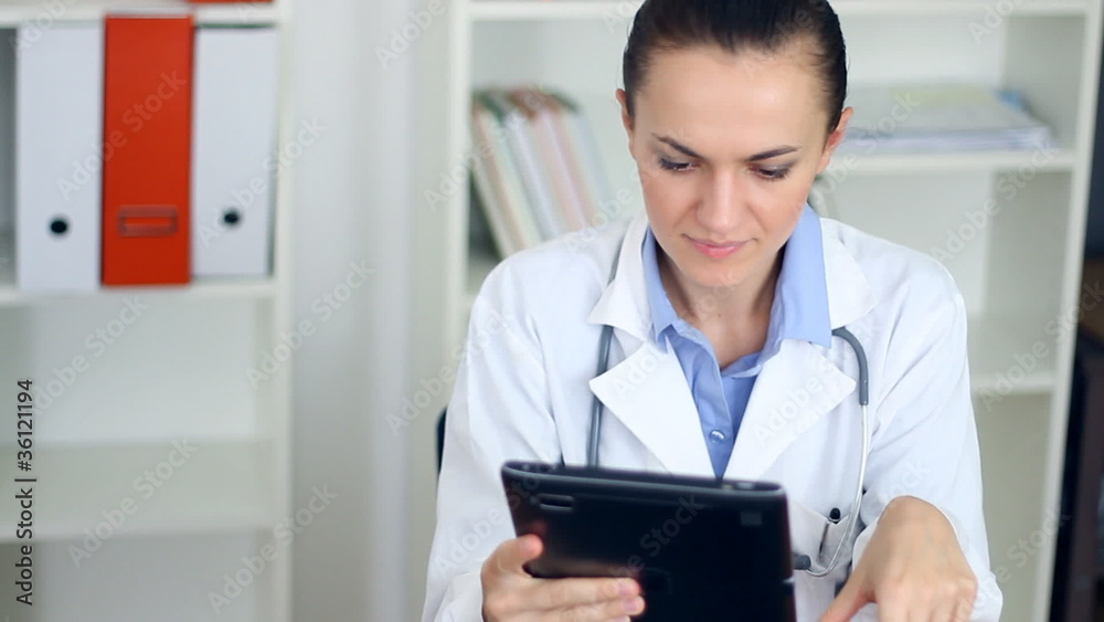 Happy female doctor with tablet computer in the office