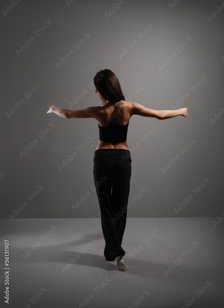 Young and sexy modern dancer over grey background