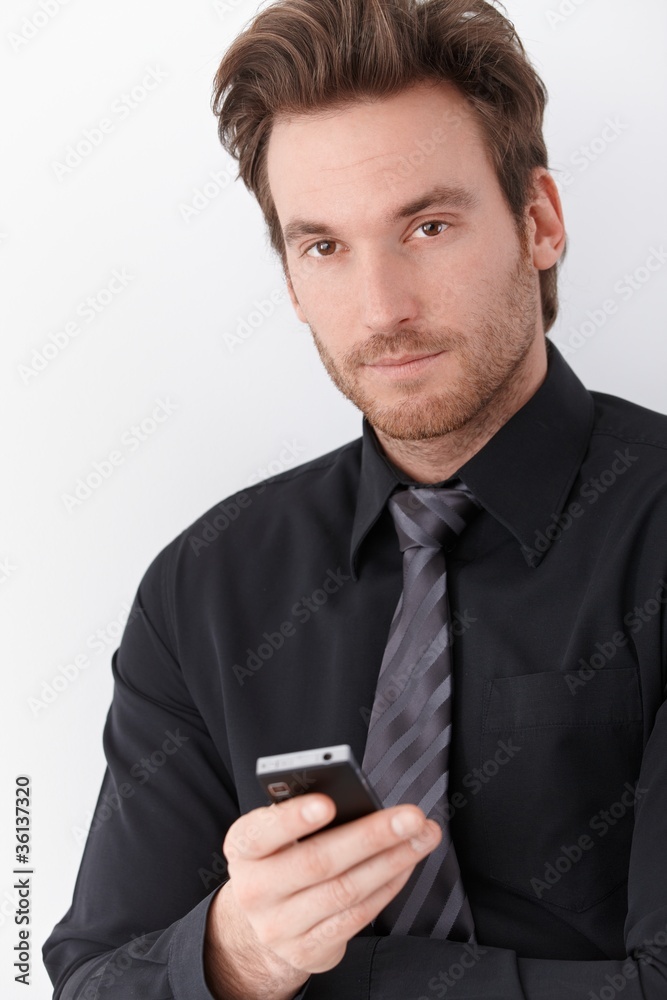 Goodlooking businessman holding mobile phone Goodlooking businessman holding mobile phone