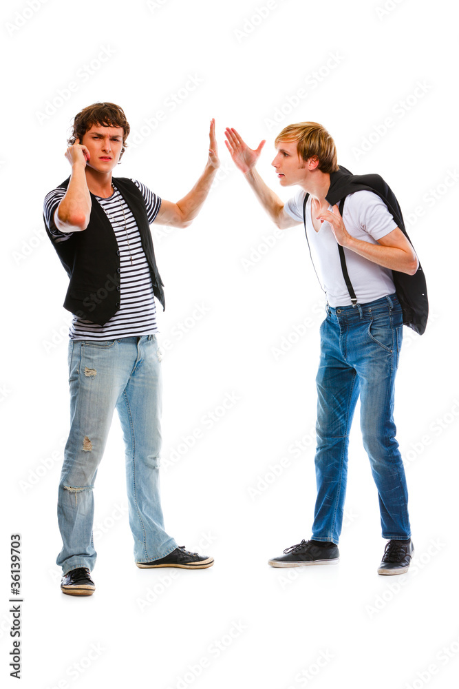 Young man with mobile showing wait gesture his indignant friend