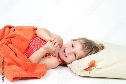 smiling child in bed isolated over white
