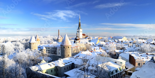 Panoramic aerial view of the old town of Tallinn, Estonia. St. Olaf's Church, fortress towers, snow-covered roofs and spires. Winter, Christmas vacations, travel destinations, sightseeing, culture