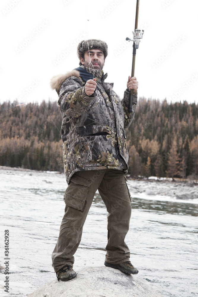 A fisherman on the river in winter A fisherman on the river in winter