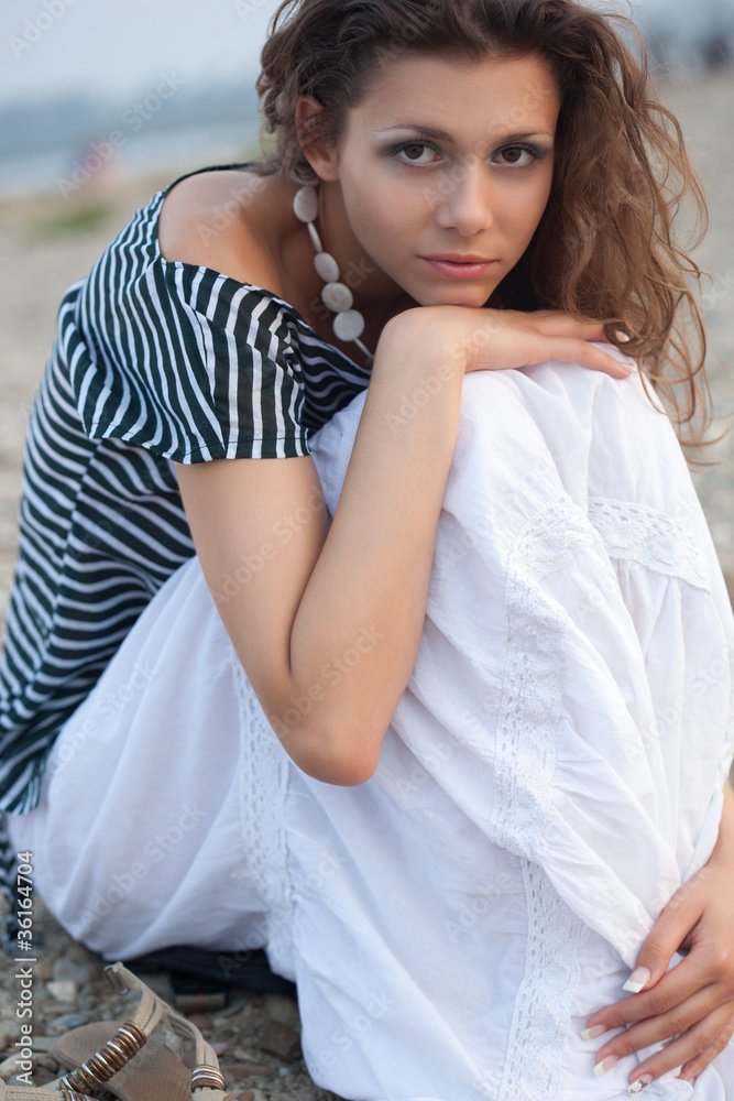 brunette woman sitting on coast brunette woman sitting on coast