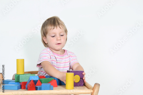cute child playing with building blocks isolated over white