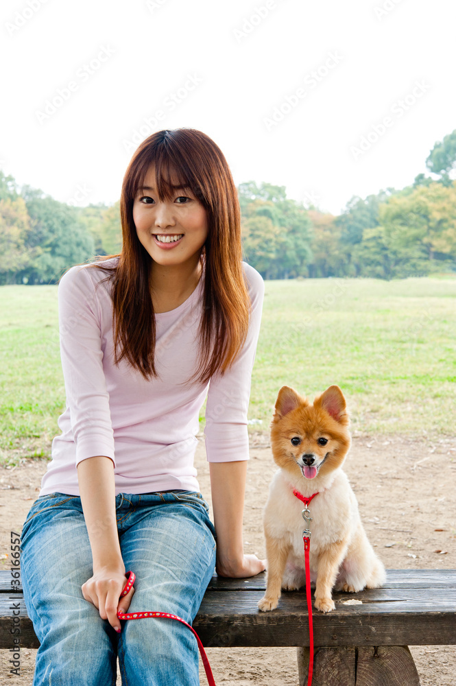 attractive asian woman with dog in the park attractive asian woman with dog in the park
