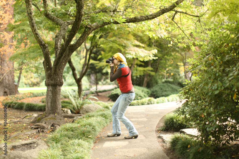 Pretty girl with a camera at a park. Pretty girl with a camera at a park.