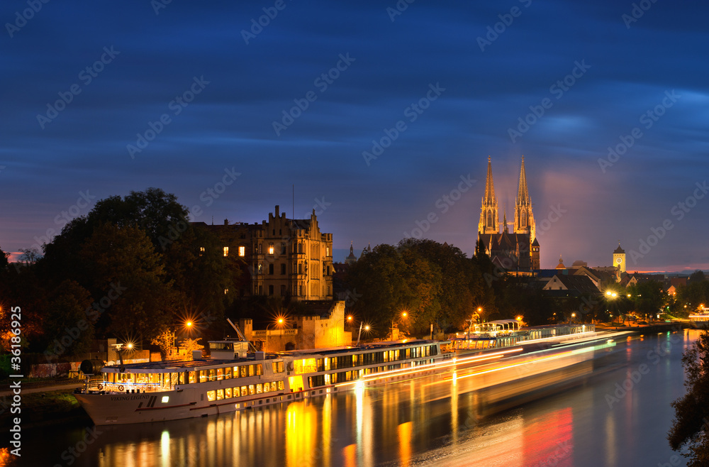 Regensburg, Donau mit Flusskreuzfahrtschiff bei Nacht mit beleuchtetem Dom 