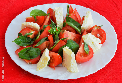 Cheese salad with tomato and green basil photo