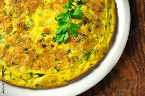 Italian omelette with parsley and parmesan cheese, closeup photo