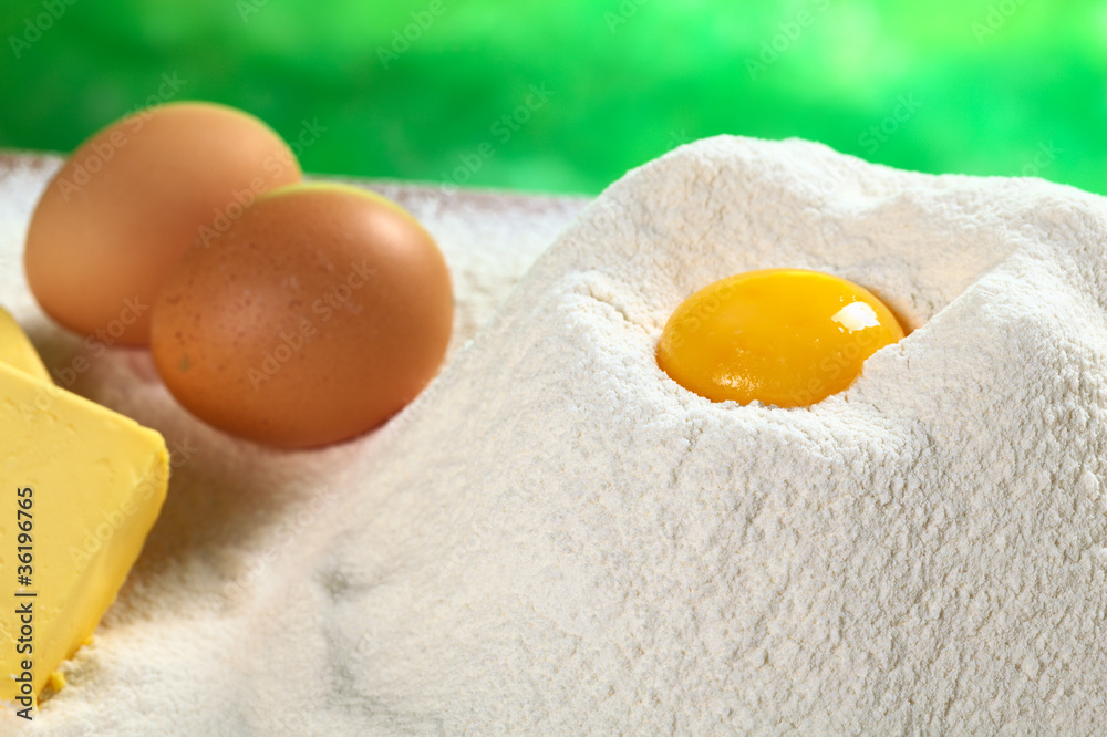 Baking Ingredients: Flour with egg yolk in the middle Baking Ingredients: Flour with egg yolk in the middle