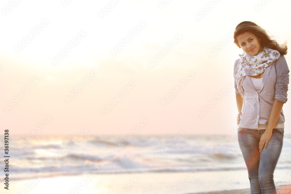 Fototapeta premium young attractive woman on sunset sea background