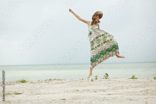 Girl jumping on beach, feels free