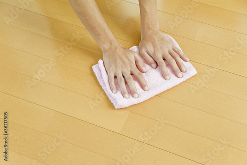 床を拭き掃除する人物の手のアップ