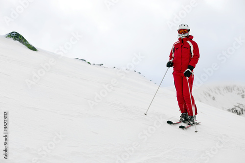 Woman skier standing on mountain slope