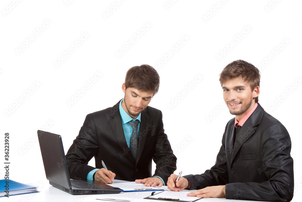 Two business people in elegant suits sitting at desk working Two business people in elegant suits sitting at desk working