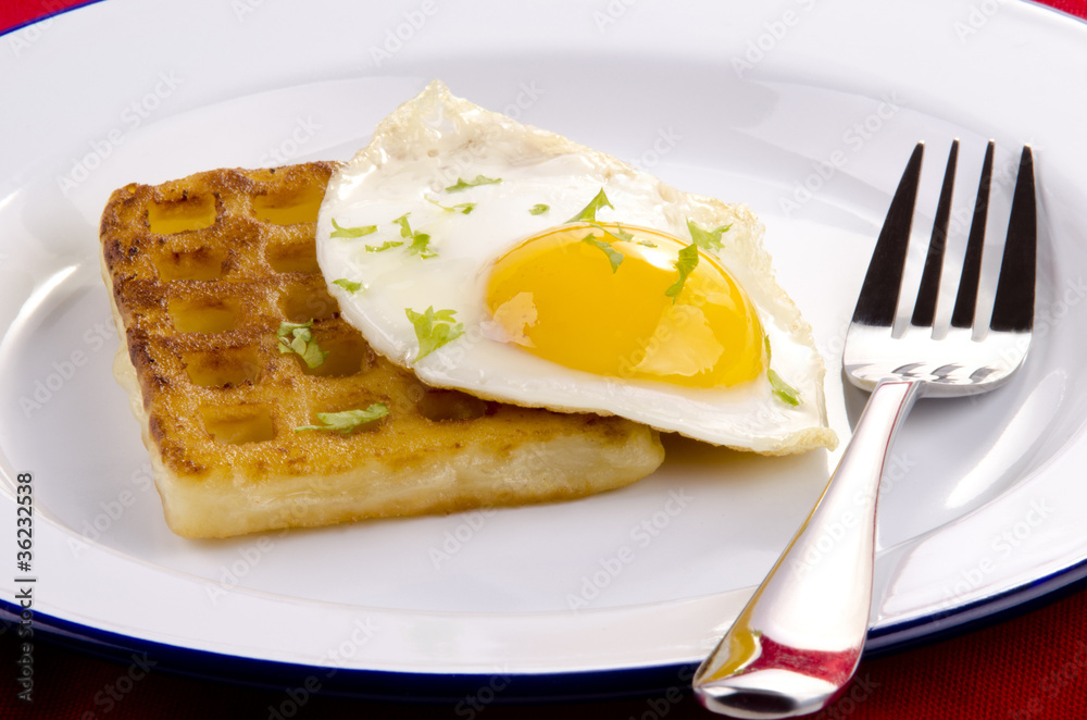 Waffel mit Spiegelei auf einem weißen Teller Waffel mit Spiegelei auf einem weißen Teller