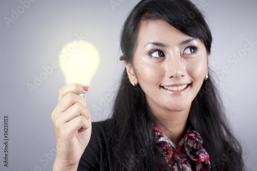 Pretty Business Woman holds a light bulb