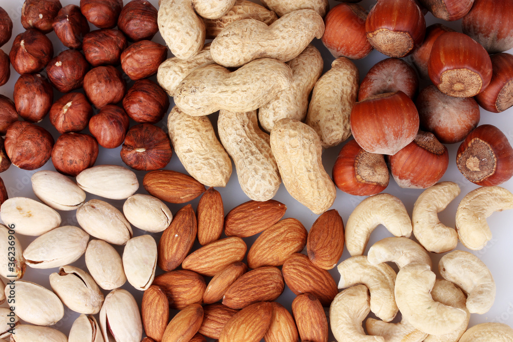 nutmeg, peanuts, hazelnuts and almonds on wooden background nutmeg, peanuts, hazelnuts and almonds on wooden background