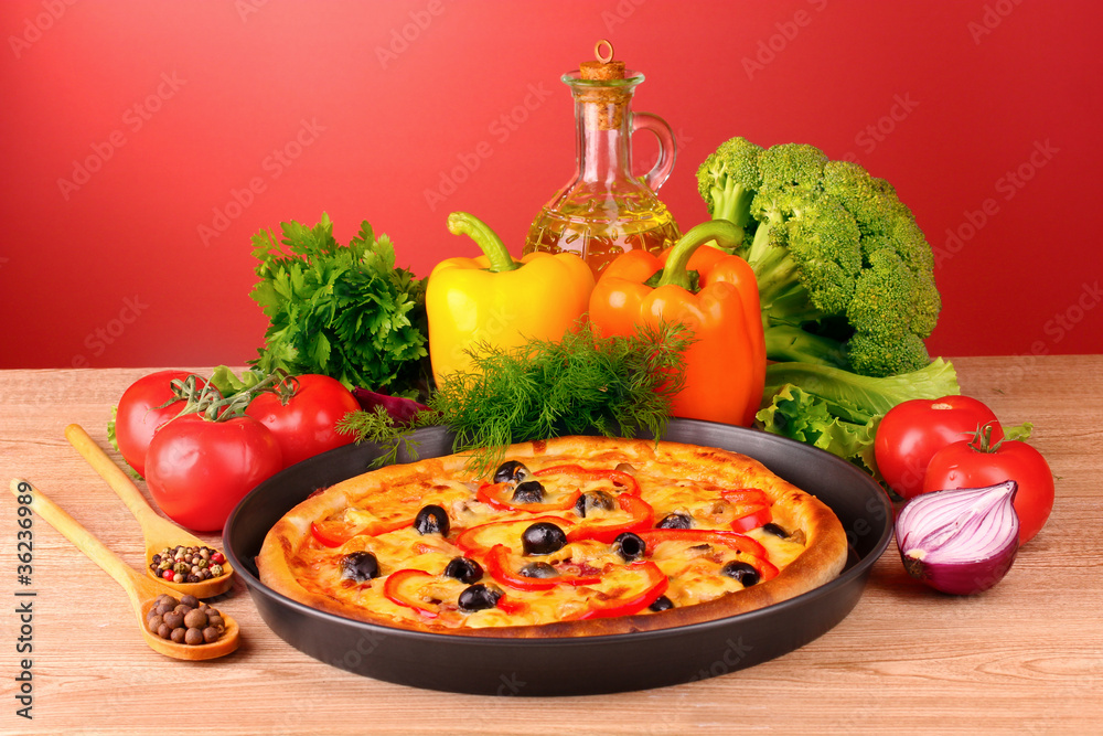 pizza and vegetables on a red background pizza and vegetables on a red background