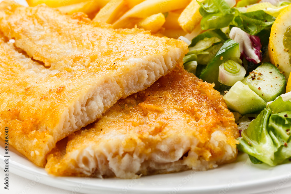Fish dish - fried fish fillet, French fries with vegetables Fish dish - fried fish fillet, French fries with vegetables