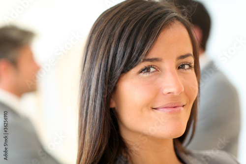 Portrait of beautiful businesswoman standing in front of group