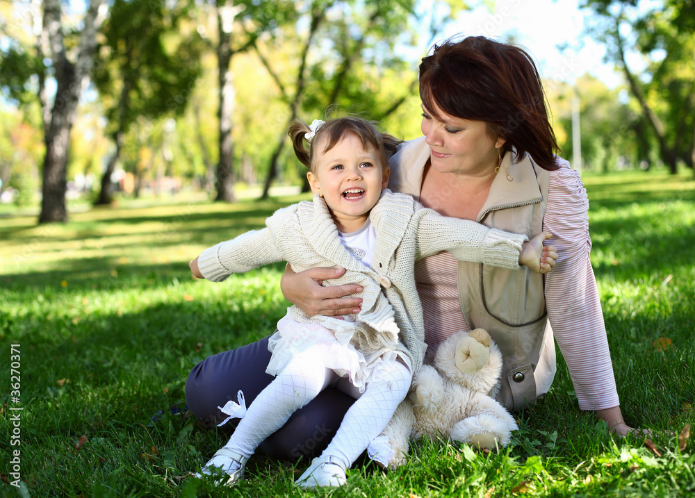 Obraz premium Grandmother with her little granddaghter in park