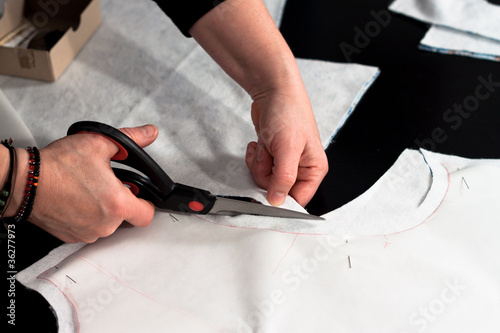 Woman hand cutting fabric after a sewing pattern photo