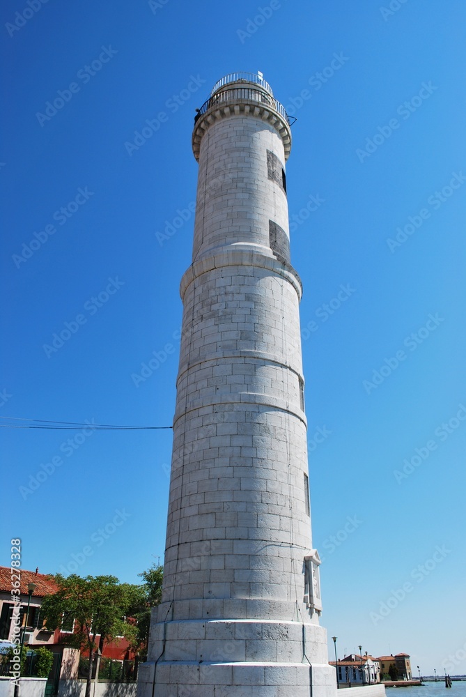 White lighthouse on Murano island in a sunny day, Venice, Italy