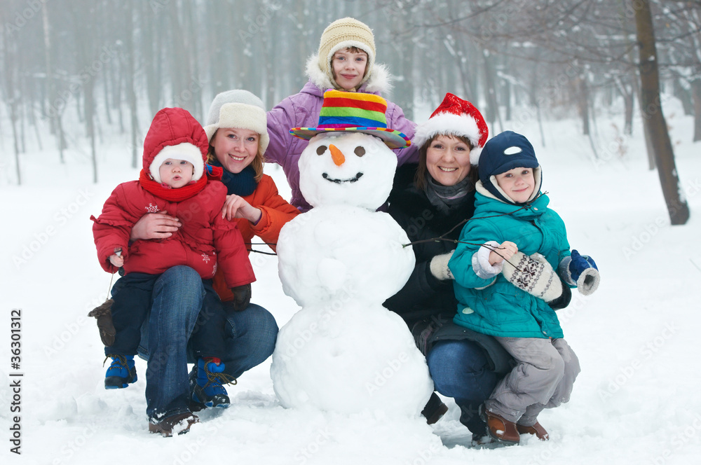 happy woman with children snowman in winter