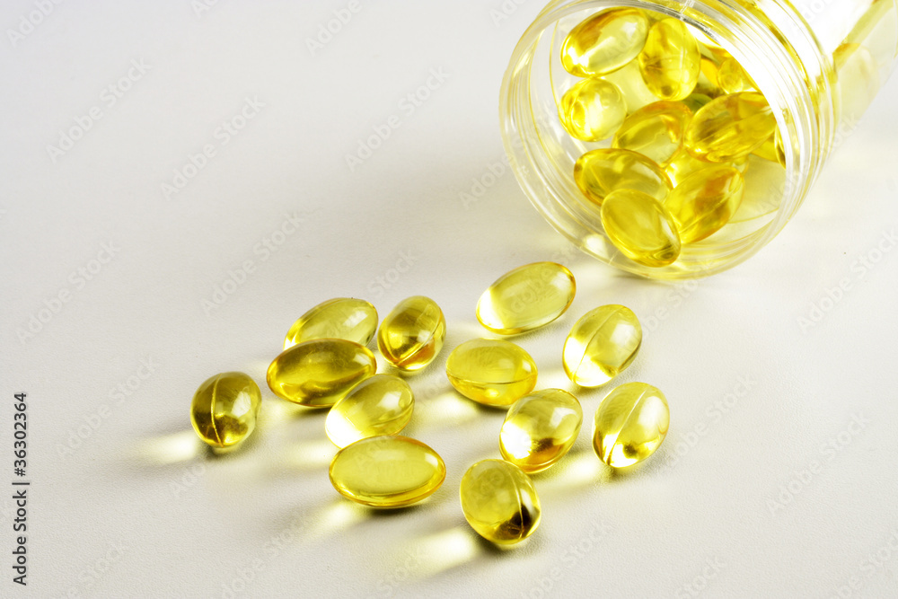 Cod liver oil pill spilled on white