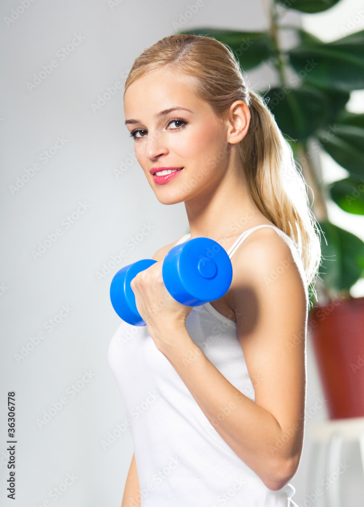 Woman exercising with dumbbell, at home Woman exercising with dumbbell, at home