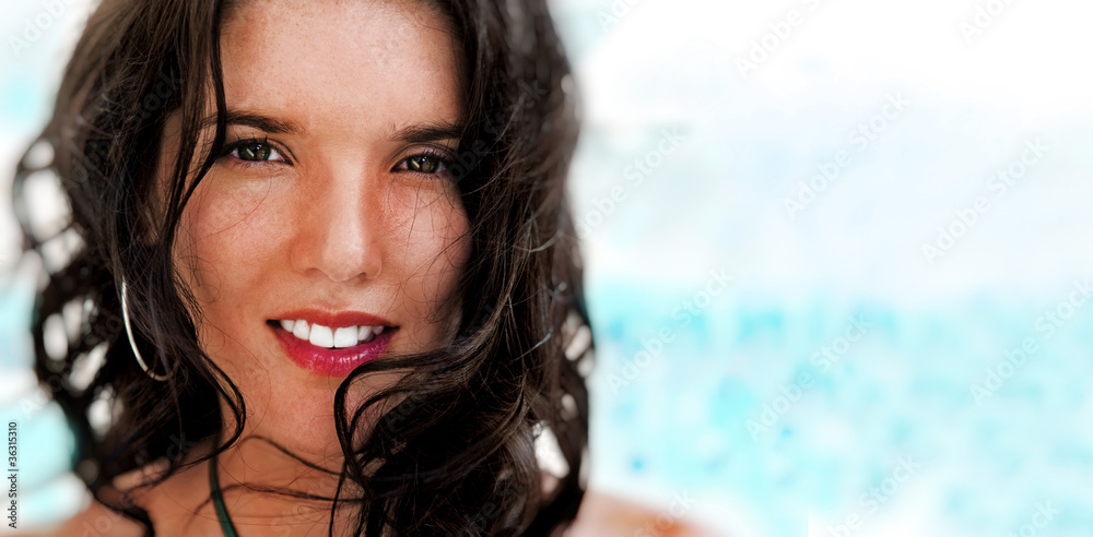 Portrait of a pretty young woman standing on beach at modern res Portrait of a pretty young woman standing on beach at modern res