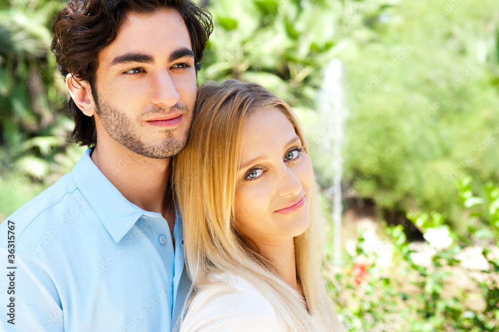 Portrait of love couple embracing outdoor in park looking happy Portrait of love couple embracing outdoor in park looking happy