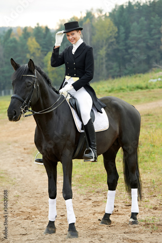 horsewoman jockey in uniform with horse