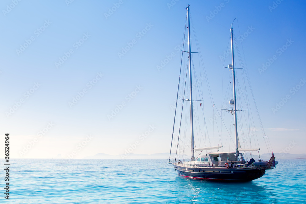 anchored sailboats in turquoise Formentera beach