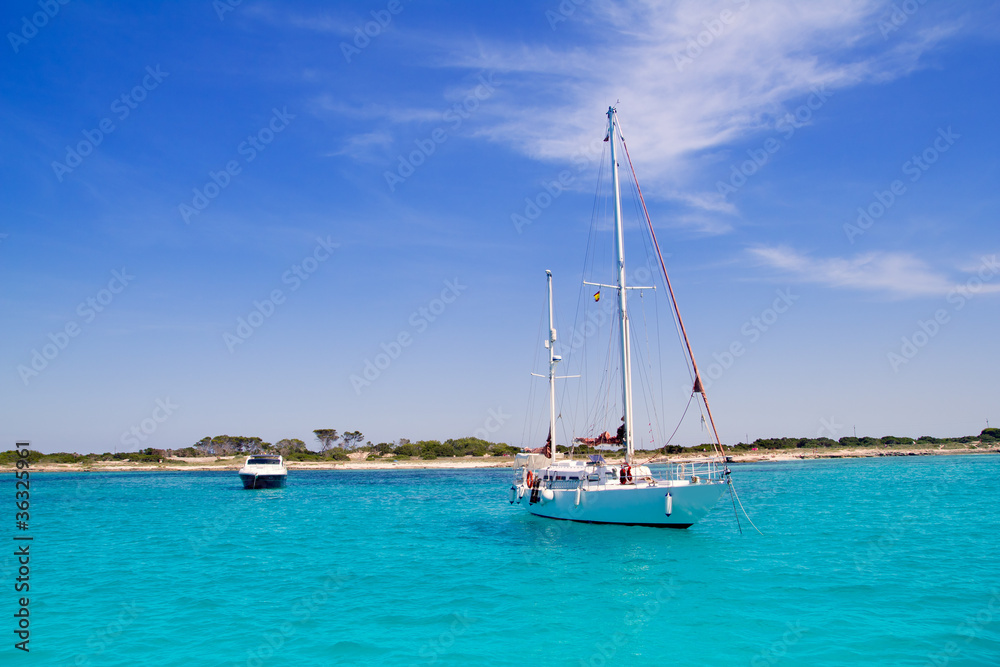 anchored sailboats in turquoise Formentera beach